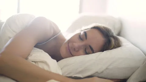 Mid-shot side view of young woman peacefully sleeping in bed Stock Footage 277967028
