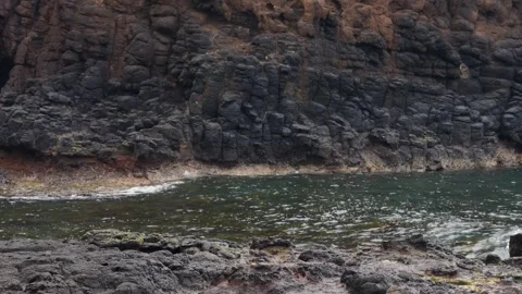 Mid shot of waves crashing over rocks Stock Footage 295079969