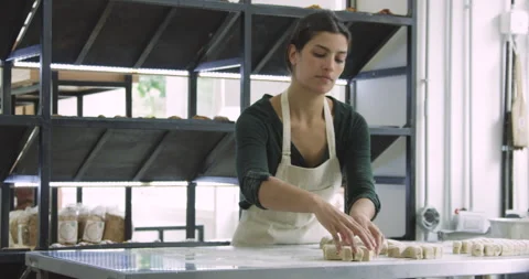 Mid-shot wide view of young female entrepreneur making bread inside her bakery Stock Footage 277958879