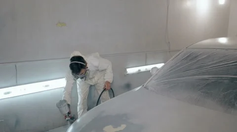 Mid shot Worker paints a car in white colour Stock Footage 65757859
