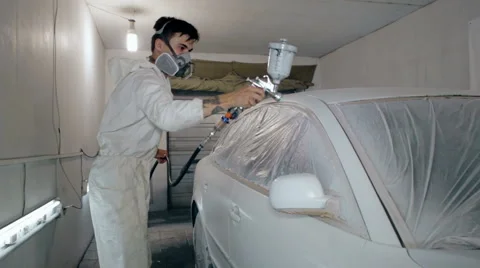 Mid shot Worker paints a car in white colour Stock Footage 65757992