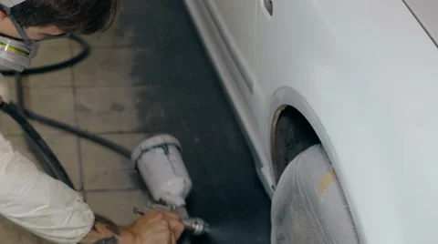 Mid shot Worker paints a car in white colour Stock Footage 65758121