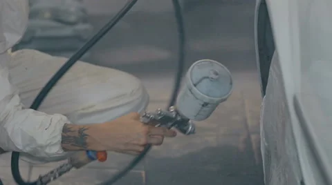 Mid shot Worker paints a car in white colour Stock Footage 65758163