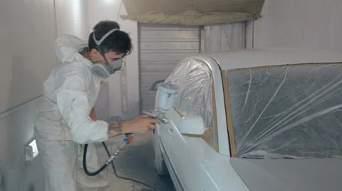 Mid shot Worker paints a car in white colour Stock Footage 65758194