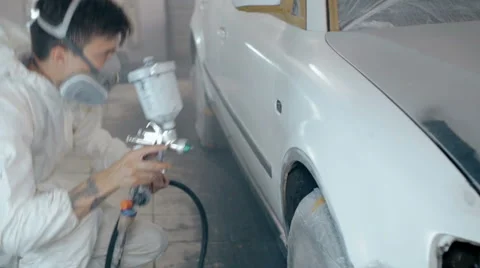 Mid shot Worker paints a car in white colour Stock Footage 65758237