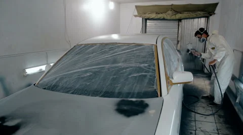 Mid shot Worker paints a car in white colour Stock Footage 65758308