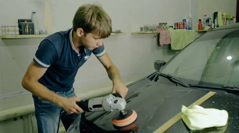 Mid shot Worker polish black car with special tools Stock Footage 65758899