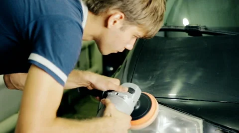 Mid shot worker polish car headlight with special tools Stock Footage 65758386