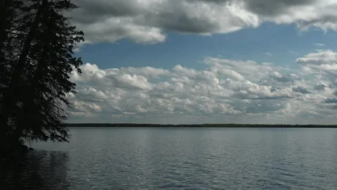 Mid summer day at a large northern lake with small waves a a pale blue sky with Stock Footage 303660486