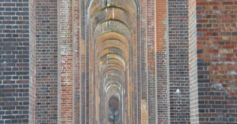 Mid tilt up shot looking through the arches of Balcombe viaduct. 動画素材 333768042