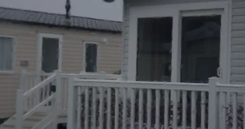 Mid zoom Shot of rain on a static caravan window with static caravans Porch in Stock Footage 346814501
