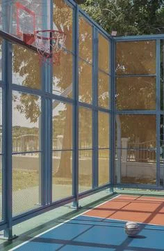 Midday shadows fall across an old basketball resting on the outdoor basketb.. Foto stock
