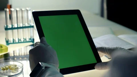 Midde aged doctor using tablet PC with green screen and smart watch in modern Stock Footage 72129561