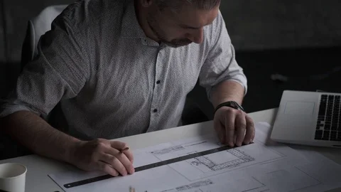 Middle age architect draws a plan on paper. Stock Footage 108616194