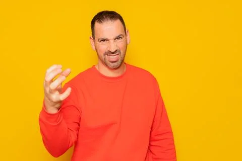Middle age bearded man in red sweater gesturing claw with obvious angry, ag.. Stock Photos