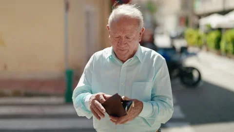 Middle age grey-haired man smiling confident counting dollars at street Video stock 225062411