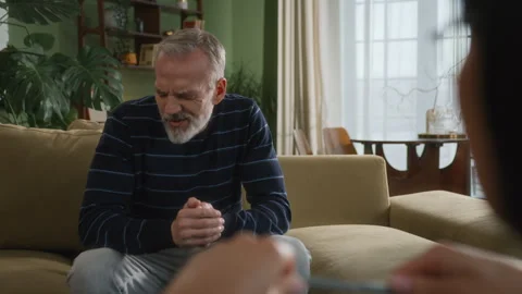 Middle age grey haired man with beard sits in psychologist office Stock Footage 273142987
