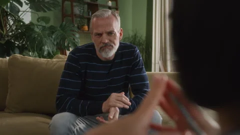 Middle age grey haired man with beard sits in psychologist office Stock Footage 273142989