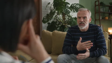 Middle age grey haired man with beard sits in psychologist office Stock Footage 273143598
