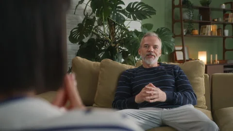 Middle age grey haired man with beard sits in psychologist office Stock Footage 273143803