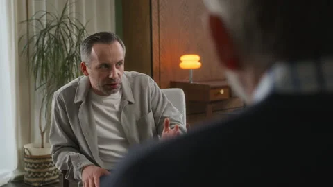 Middle age grey haired man with beard sits in psychologist office Stock Footage 273295484