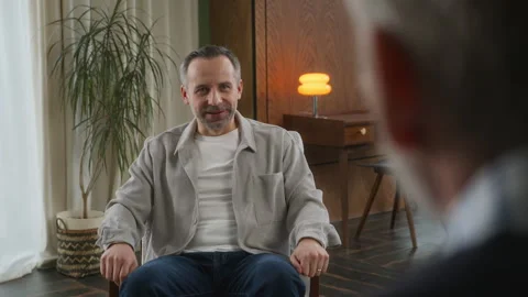 Middle age grey haired man with beard sits in psychologist office Stock Footage 273295928