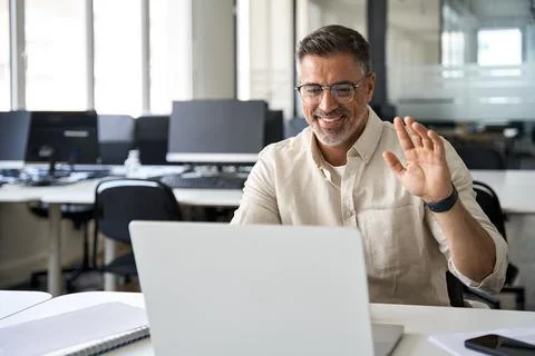 Middle-age Hispanic man using computer remote for business studying, online work Stock Photos