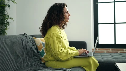 Middle age hispanic woman using laptop sitting on sofa at street Stock Footage 232874021