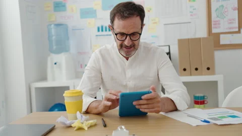 Middle age man business worker smiling confident using touchpad at office Video stock 220154179