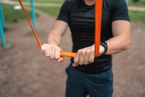 Middle age man doing strength exercises with resistance bands outdoors in park Stock Photos