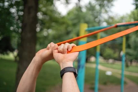 Middle age man doing strength exercises with resistance bands outdoors in park Stock Photos