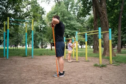 Middle age man doing strength exercises with resistance bands outdoors in park Stock Photos