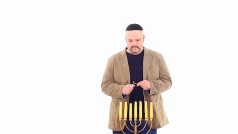 Middle age man in Kippah ignites Menorah candles white screen Stock Footage 105002124