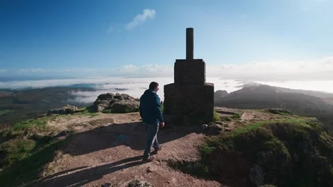 Middle age man reaching the summit of Sacred Peak in Galicia Stock Footage 336719255