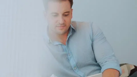 Middle age man sit on sofa read fable book increasing imagination. Divergence. Stock Photos