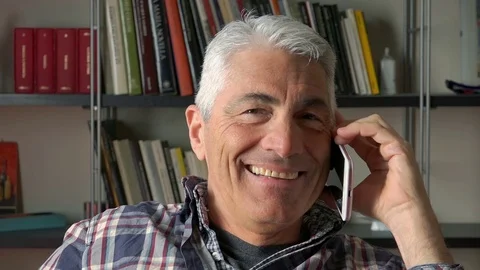 Middle-age man smiling during a phone call with a smartphone  Video stock 73168155