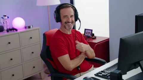 Middle age man streamer smiling confident sitting with arms crossed gesture a Video stock 221111080