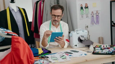Middle age man tailor smiling confident using touchpad at tailor shop Stock Footage 205530351