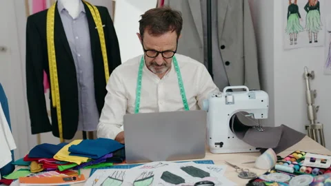 Middle age man tailor using laptop at tailor shop Video stock 221111443