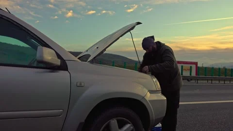 Middle age man trying to fix car breakdown on highway Stock Footage 224064074