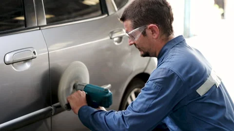 Middle age man using auto polisher to wax body parts, garage business owner.. Stock Footage 246058410