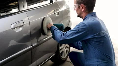 Middle age man using auto polisher to wax body parts, garage business owner.. Stock Footage 246066483