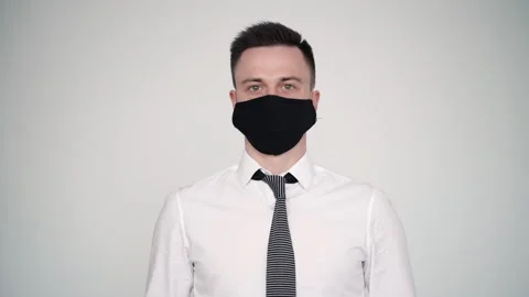 Middle age manager man take off black prevention mask on white isolated Stock Footage 130196276