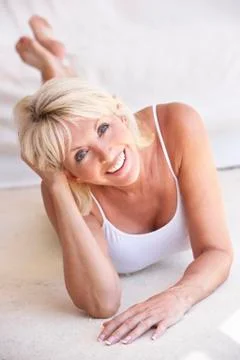 Middle age woman lying down strikes a pose Stock Photos