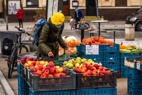 Middle age woman with mask is purchasing fruits and vegetables at the local m Stock Photos