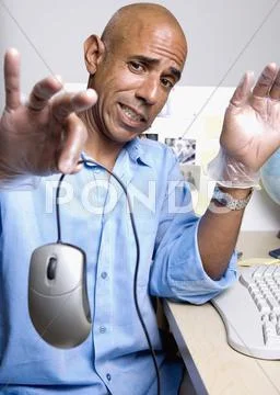 Middle-aged African businessman holding computer mouse Stock Photos