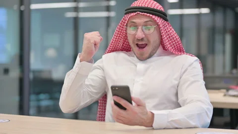 Middle Aged Arab Man Celebrating Success on Smartphone in Office 스톡 동영상 152521749