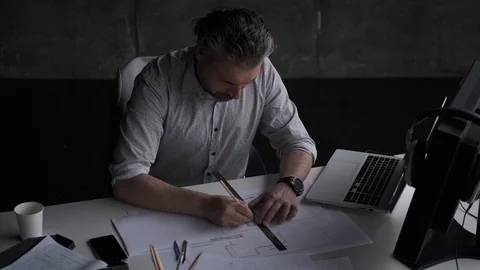 Middle aged architect draws plans on paper. business man working in the office Stock Footage 108616265