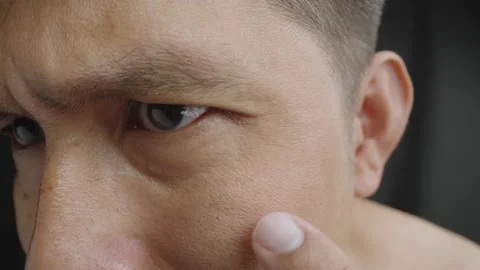 Middle-aged Asian man examining wrinkles in eyes area. Stock Footage 235002183