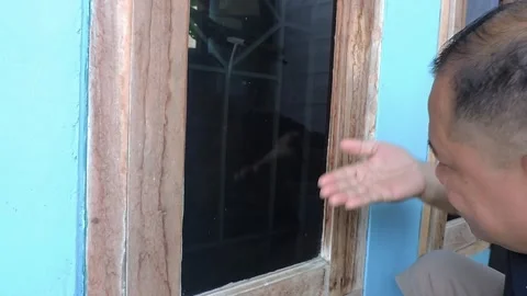 A middle-aged Asian man is looking at a head whose hair is starting to fall out Stock Footage 285830360